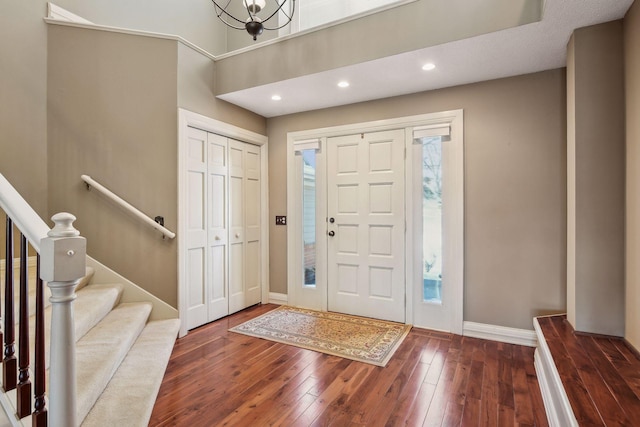 entrance foyer featuring dark wood-type flooring and a notable chandelier