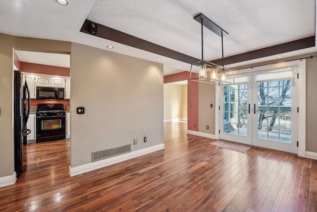 interior space featuring wood-type flooring, french doors, and a textured ceiling