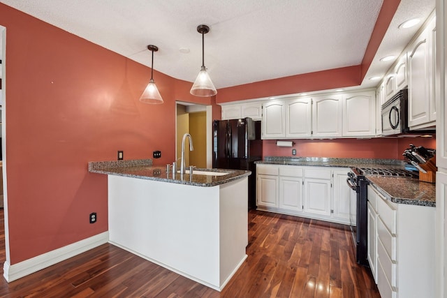 kitchen with hanging light fixtures, white cabinets, black appliances, and kitchen peninsula