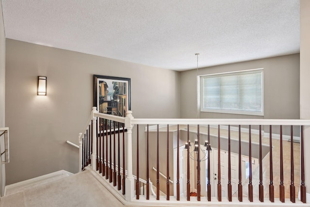 hallway featuring carpet floors and a textured ceiling