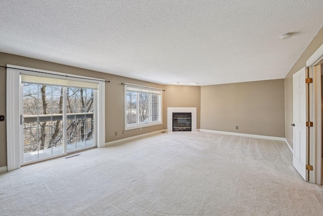 unfurnished living room with light carpet and a textured ceiling