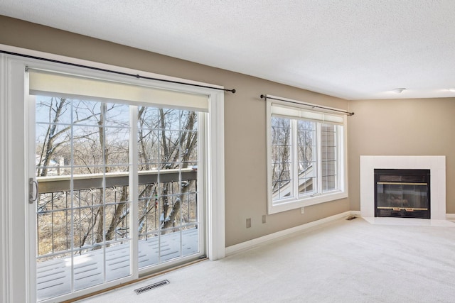 unfurnished living room with carpet floors and a textured ceiling