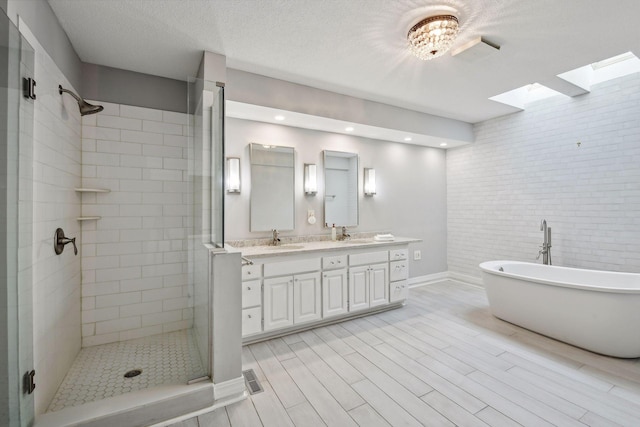 bathroom featuring a textured ceiling, shower with separate bathtub, and vanity