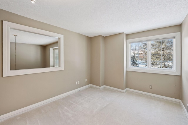 carpeted empty room featuring a textured ceiling