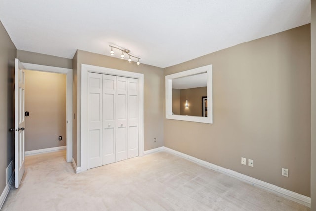 unfurnished bedroom with a closet and light carpet