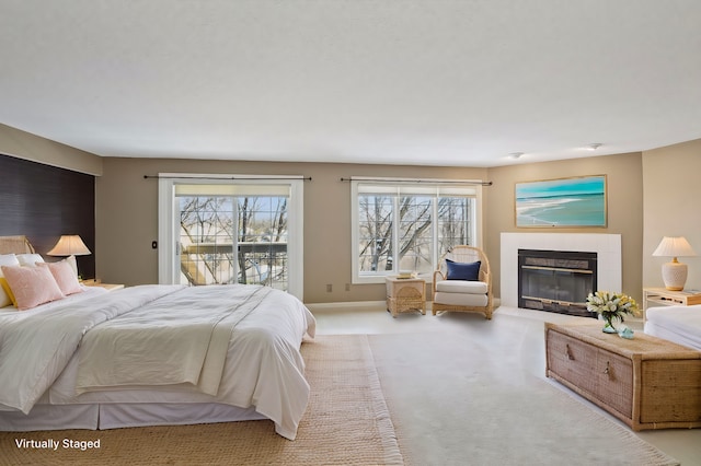 carpeted bedroom with access to exterior, a fireplace, and multiple windows