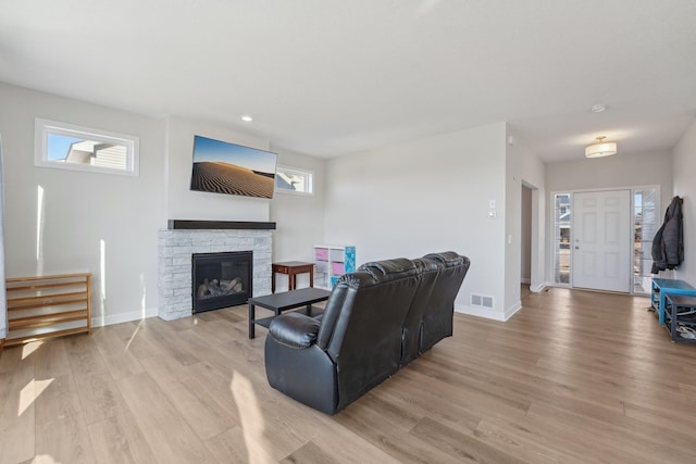 living room featuring a fireplace and light wood-type flooring