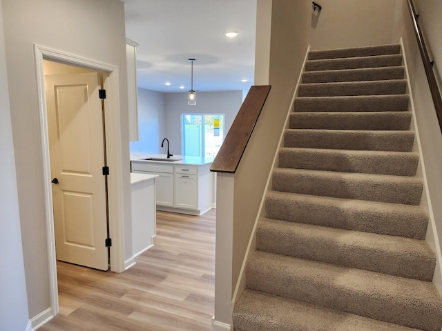 stairway featuring hardwood / wood-style flooring and sink