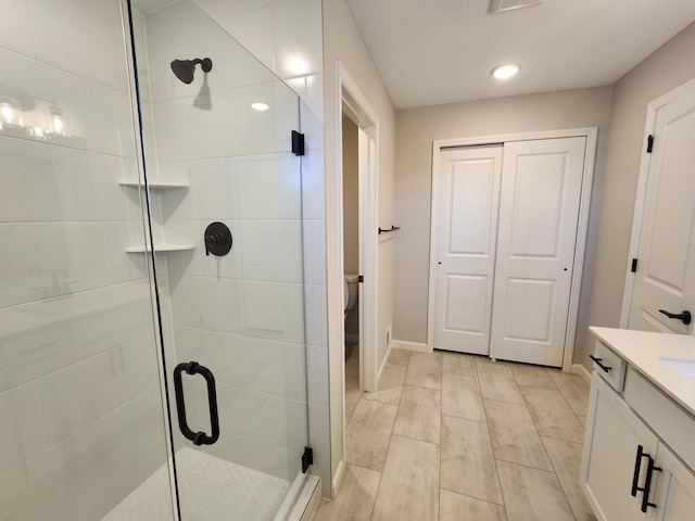 bathroom with vanity, toilet, and a shower with door