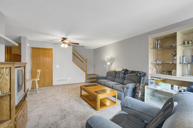 living room featuring light carpet, a textured ceiling, and ceiling fan