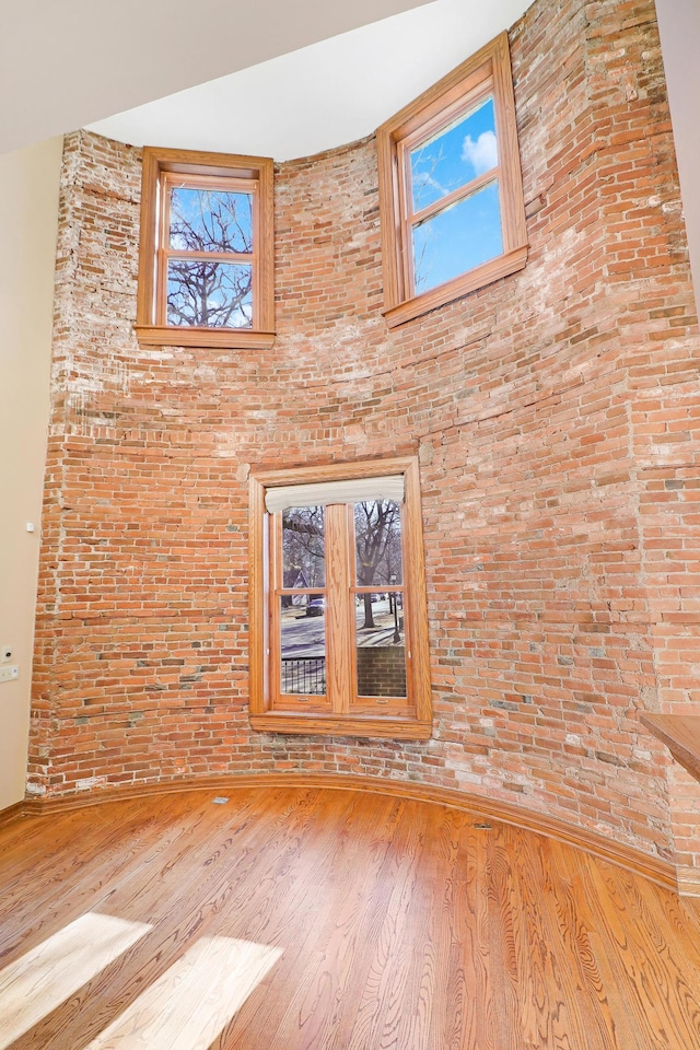 empty room featuring hardwood / wood-style flooring and a high ceiling