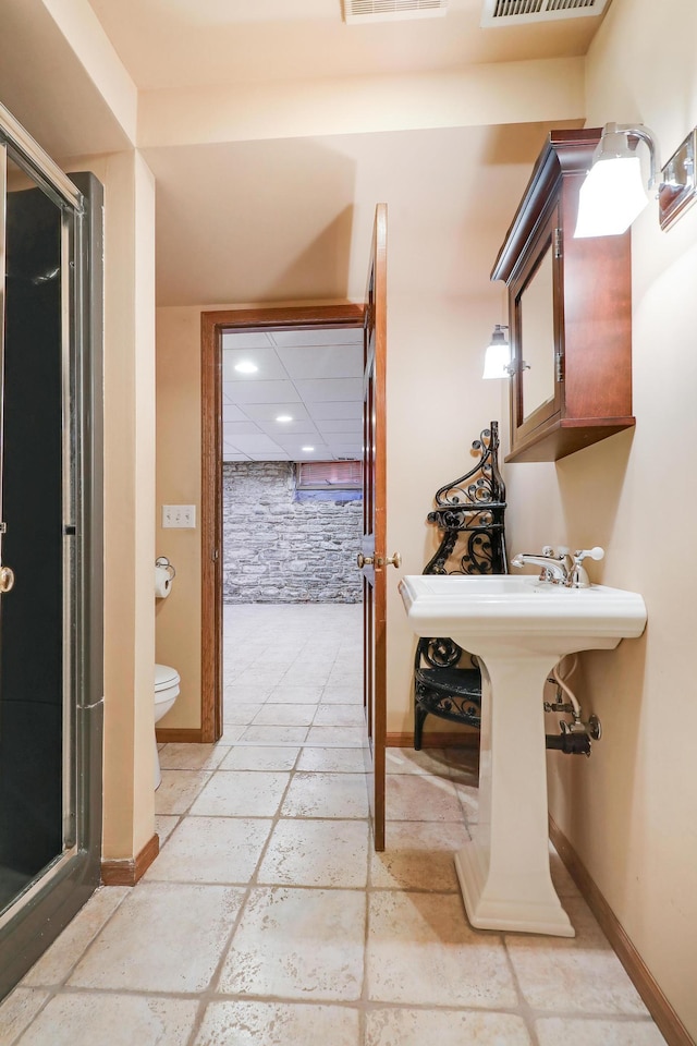 bathroom with toilet and a shower with door