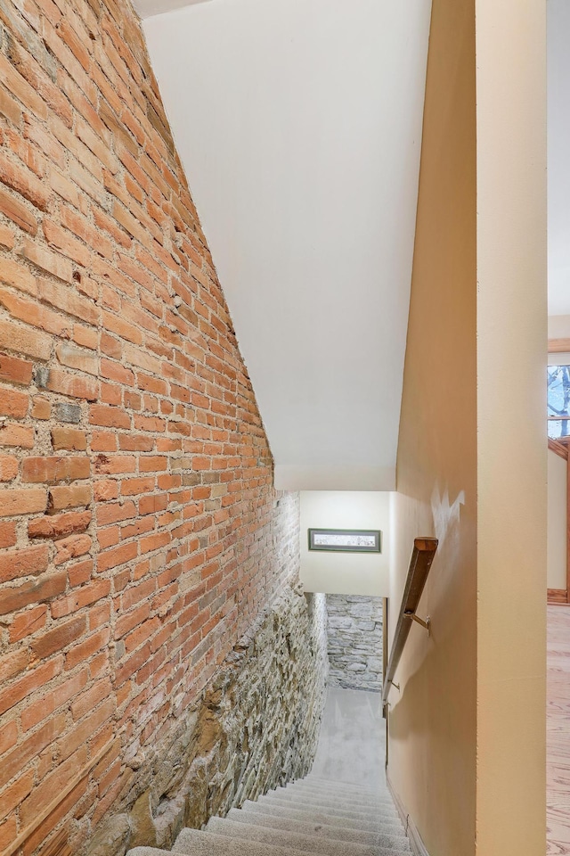 stairway featuring carpet flooring and vaulted ceiling