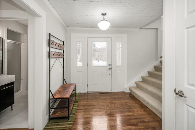 entryway with dark hardwood / wood-style flooring and ornamental molding