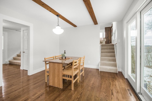 dining area featuring beam ceiling and dark hardwood / wood-style flooring