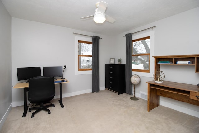 carpeted office space featuring ceiling fan