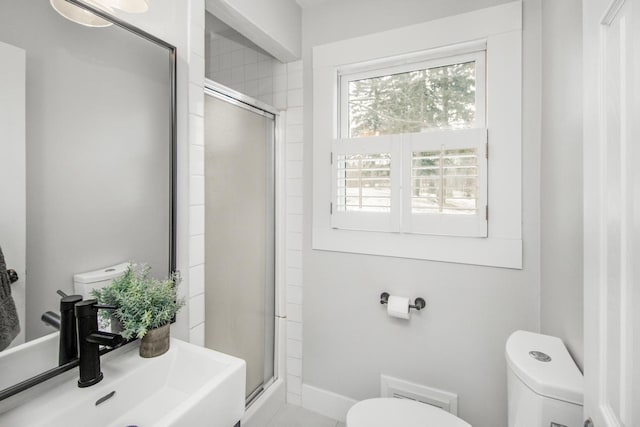 bathroom featuring sink, an enclosed shower, and toilet