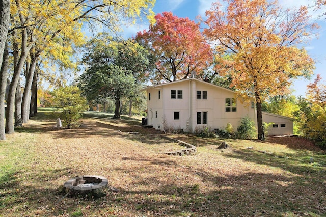 exterior space featuring a fire pit and a lawn