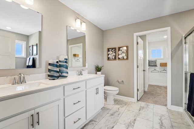 bathroom featuring vanity, toilet, and a shower with shower door