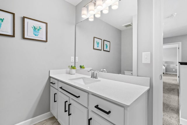 bathroom with visible vents, toilet, vanity, and baseboards