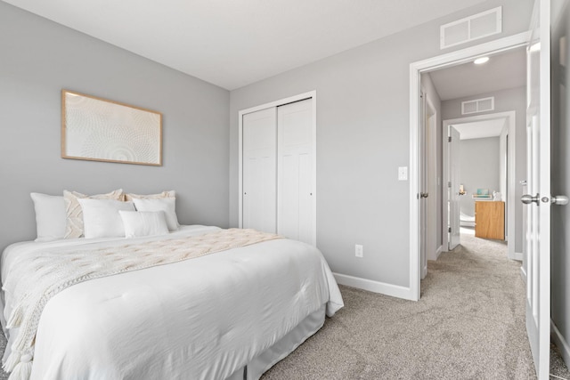 carpeted bedroom with a closet, visible vents, and baseboards