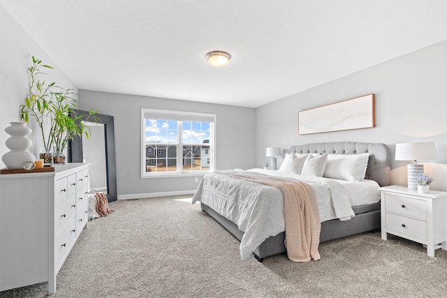 bedroom with light colored carpet and baseboards