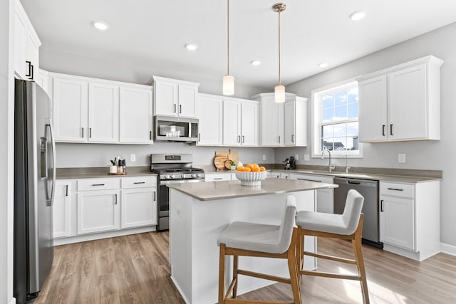 kitchen featuring light wood-style flooring, appliances with stainless steel finishes, and white cabinets