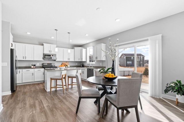 dining area with recessed lighting, baseboards, and light wood finished floors