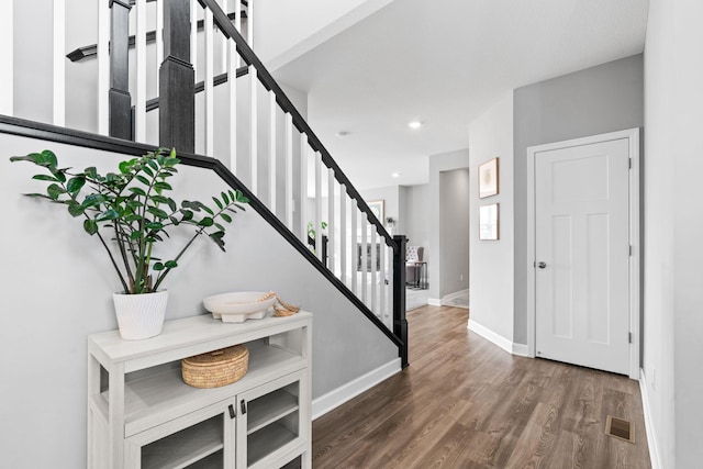 entryway featuring visible vents, wood finished floors, recessed lighting, stairway, and baseboards