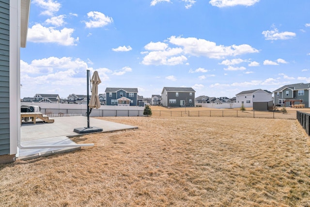 view of yard featuring a residential view, a fenced backyard, and a patio area