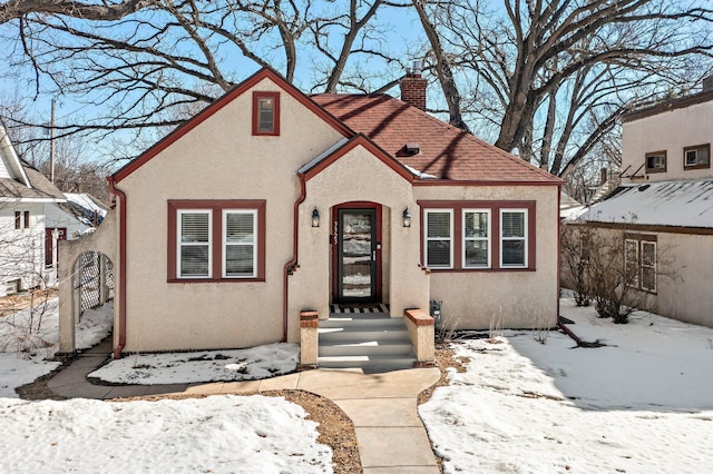 view of front of house featuring stucco siding and a chimney