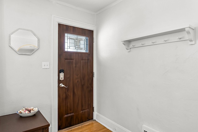 foyer featuring light wood-type flooring, baseboards, and ornamental molding