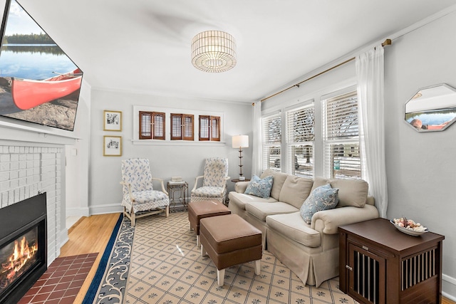 living area with a brick fireplace and baseboards