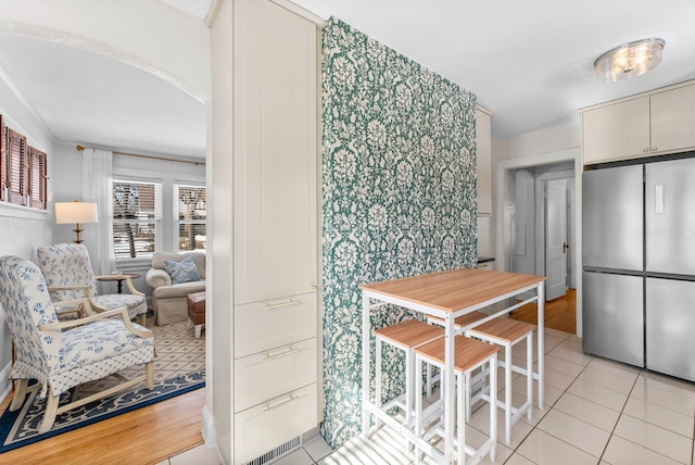 dining area with arched walkways and light tile patterned floors