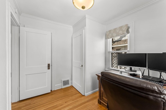 office space with visible vents, baseboards, ornamental molding, and light wood-style flooring