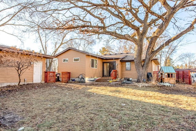 back of house featuring a yard and a shed