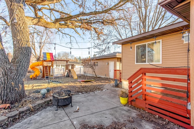 view of patio with a fire pit and a playground