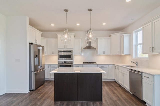 kitchen with sink, a kitchen island, pendant lighting, white cabinets, and appliances with stainless steel finishes