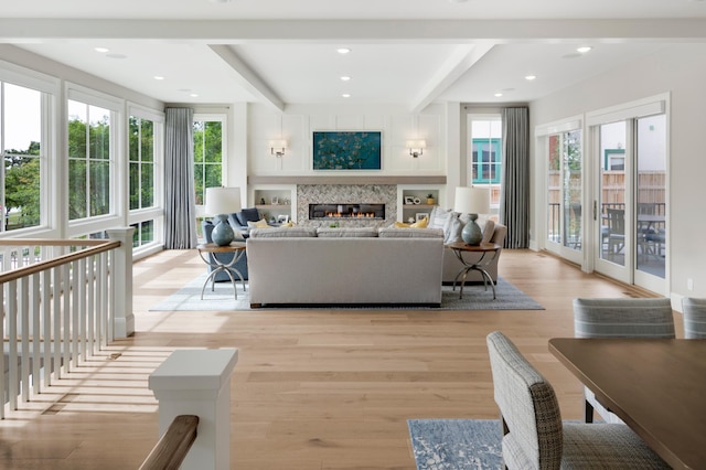 living room featuring beamed ceiling and light wood-type flooring