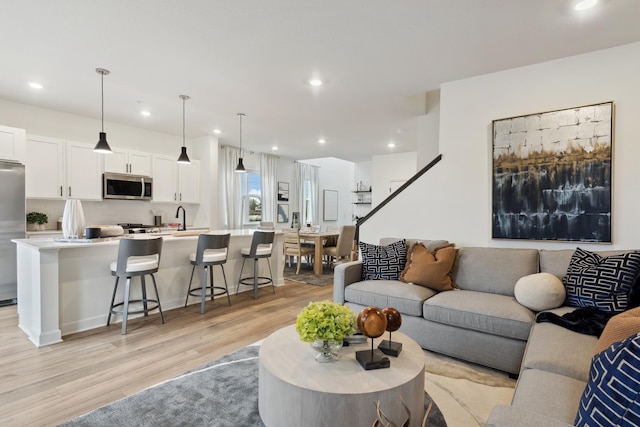 living room with sink and light wood-type flooring