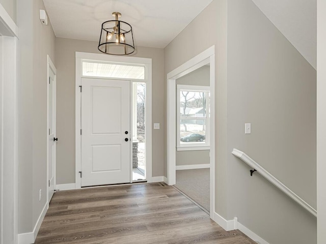 foyer featuring hardwood / wood-style floors, an inviting chandelier, and a wealth of natural light