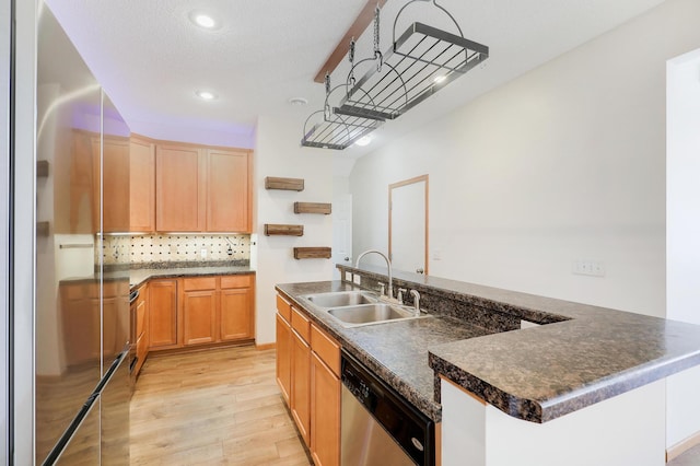 kitchen featuring dishwasher, sink, an island with sink, and light hardwood / wood-style flooring