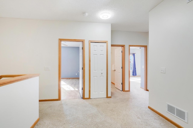 carpeted empty room featuring a textured ceiling