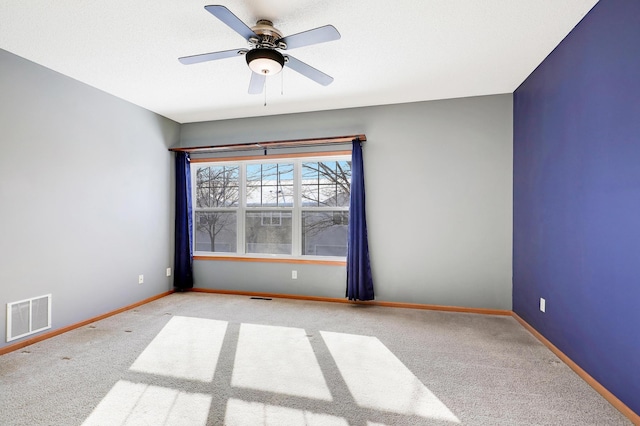 empty room with ceiling fan and light carpet