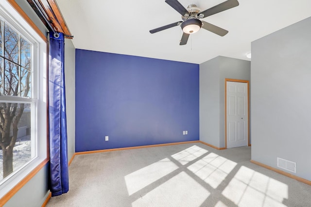 spare room with ceiling fan and light colored carpet