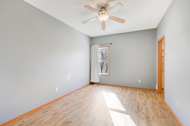 spare room with ceiling fan, a textured ceiling, and light wood-type flooring