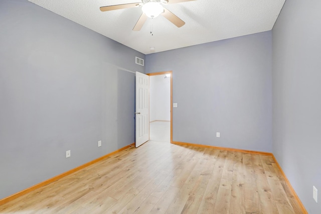 unfurnished room featuring ceiling fan, light hardwood / wood-style floors, and a textured ceiling