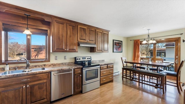 kitchen with a notable chandelier, sink, stainless steel appliances, and a wealth of natural light