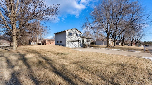 view of side of property featuring a lawn and a garage