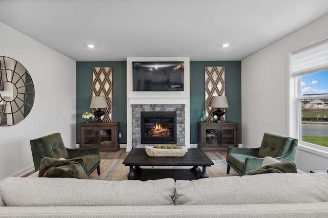 living room featuring hardwood / wood-style floors and a stone fireplace